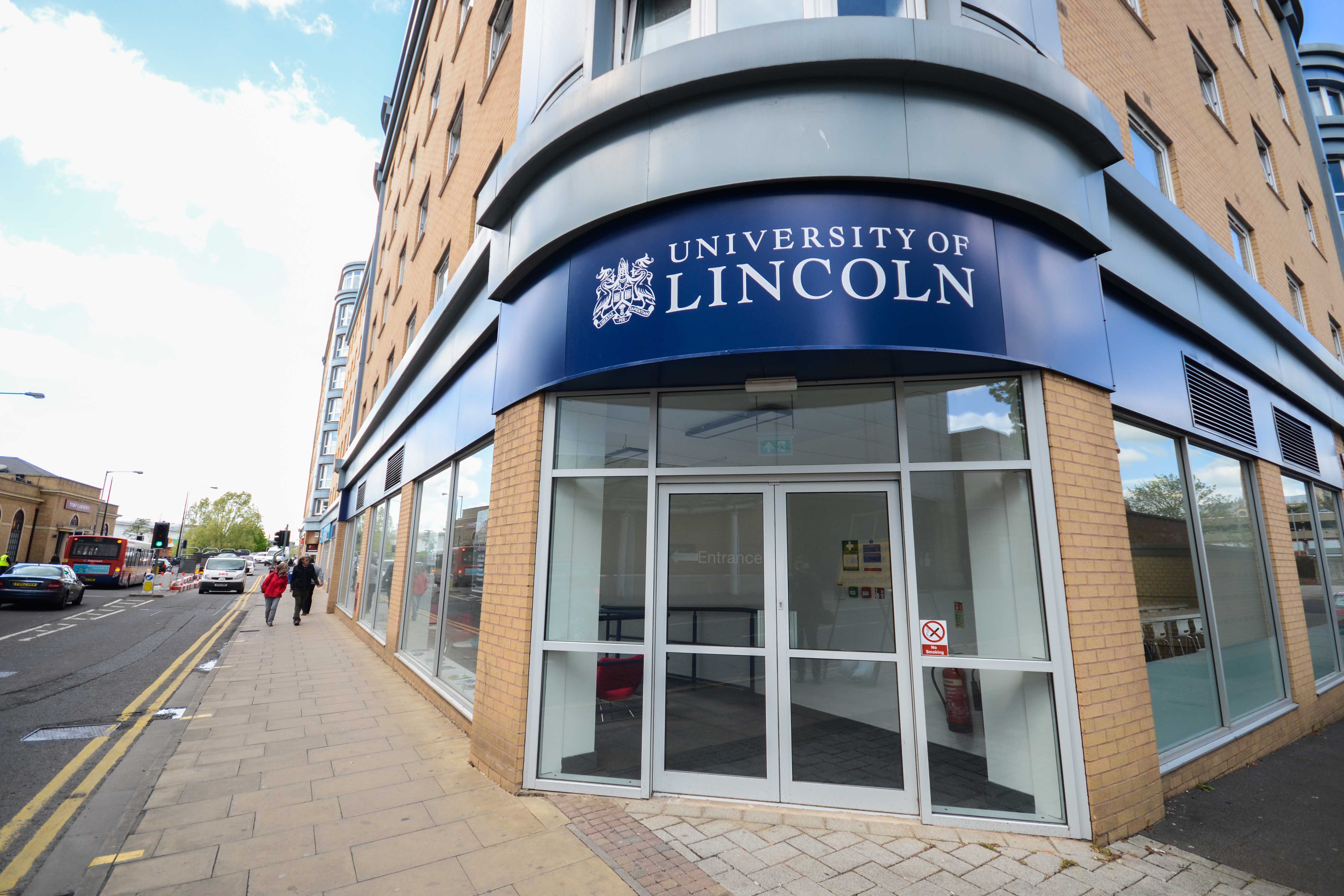 Image of a rounded front entrance to a ground floor section of a building. A University of Lincoln banner is above the doorway in blue.