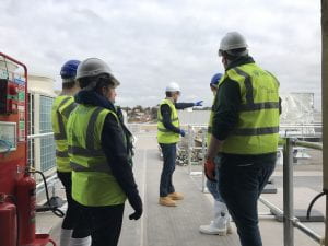 Image of people standing on a site wearing protective gear