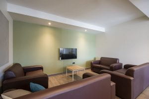 Image of a living room with tv on the wall, and sofas