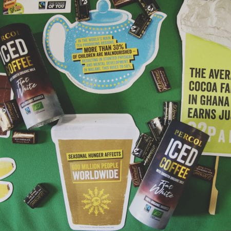 Image of some iced coffee cartons laid on a table with leaflets and small packets of chocolate