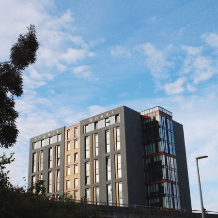 Image of an accommodation tower block with a blue cloudy sky surrounding