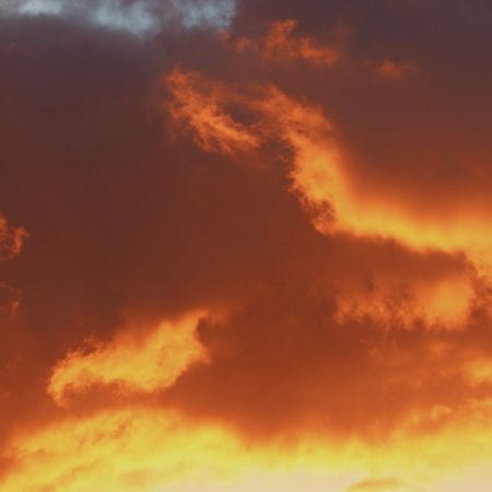 Image of a sunset cloudy sky full of colours, oranges, yellows.