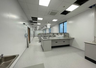 Image of a laboratory with white walls and grey desks.