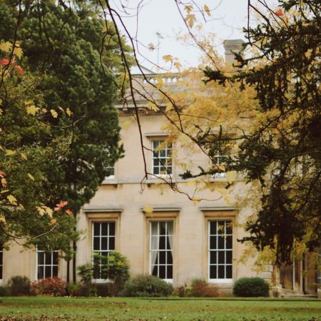 Image of an old hall surrounded by autumn trees