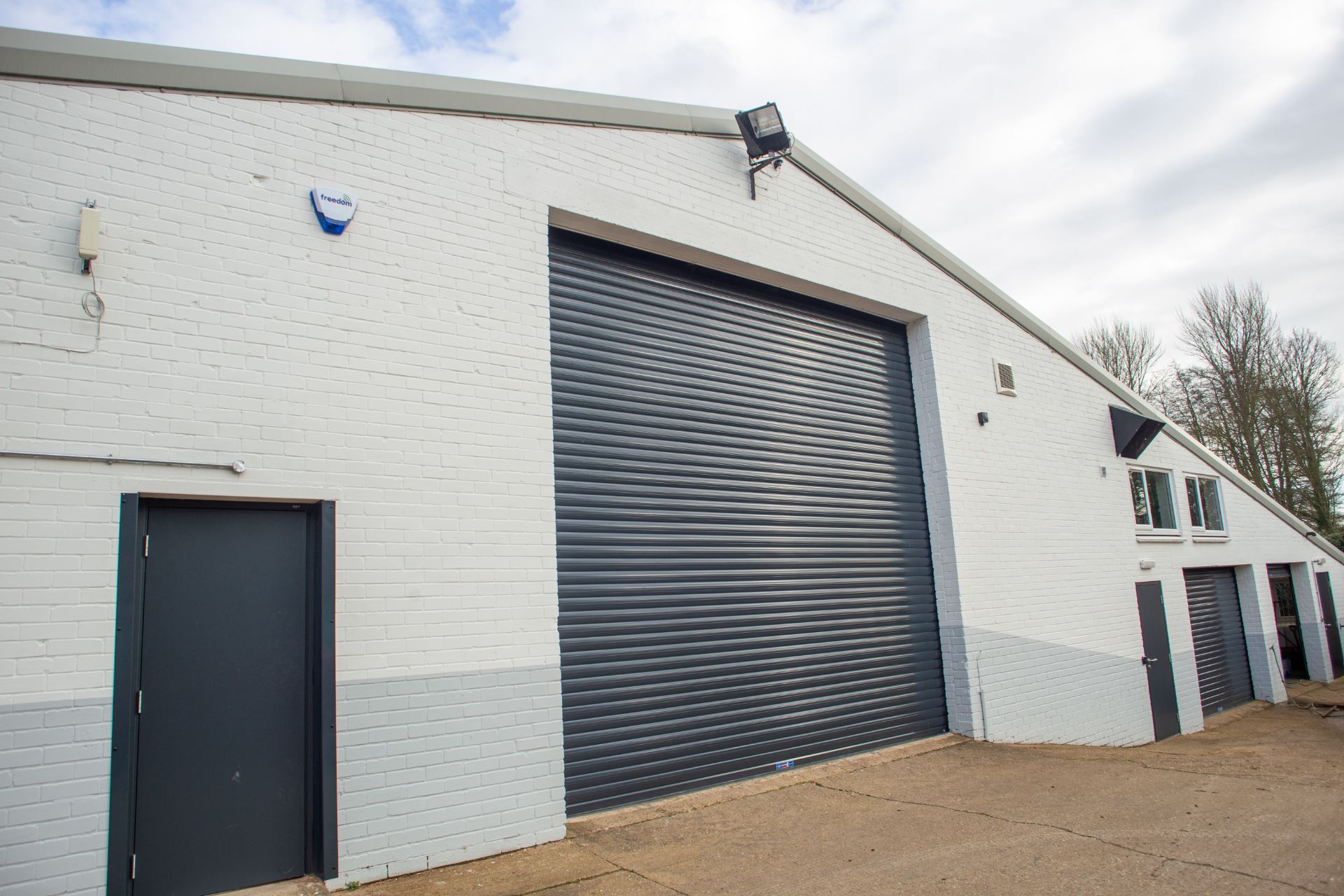 Image of a large shed like workshop with a dark grey shutter door