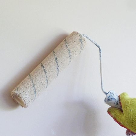 Image of a wall being painted white with a roller