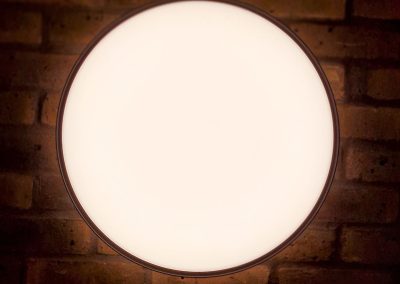 A circular light on a brick wall